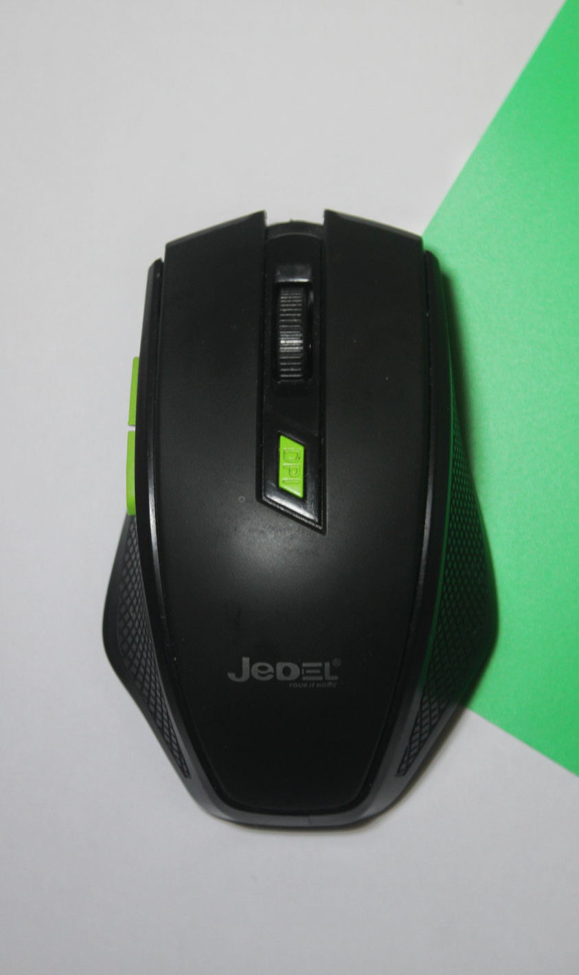 A product photograph by a UGC Creator of a computer mouse laying on top of a green and white background